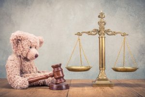 Teddy bear next to scales and gavel